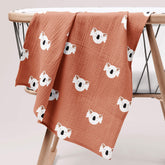 Koala print muslin swaddle draped over wooden stand
